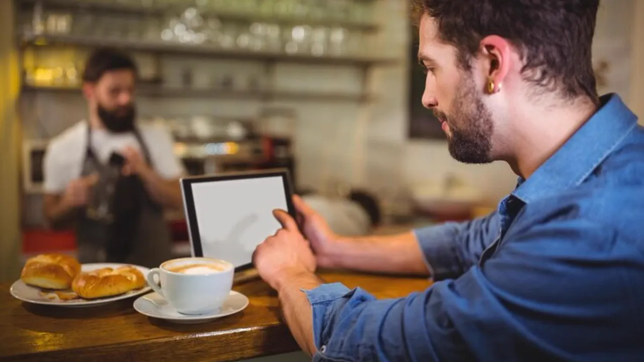 Profesional de hostelería usando una tablet mientras atiende un restaurante