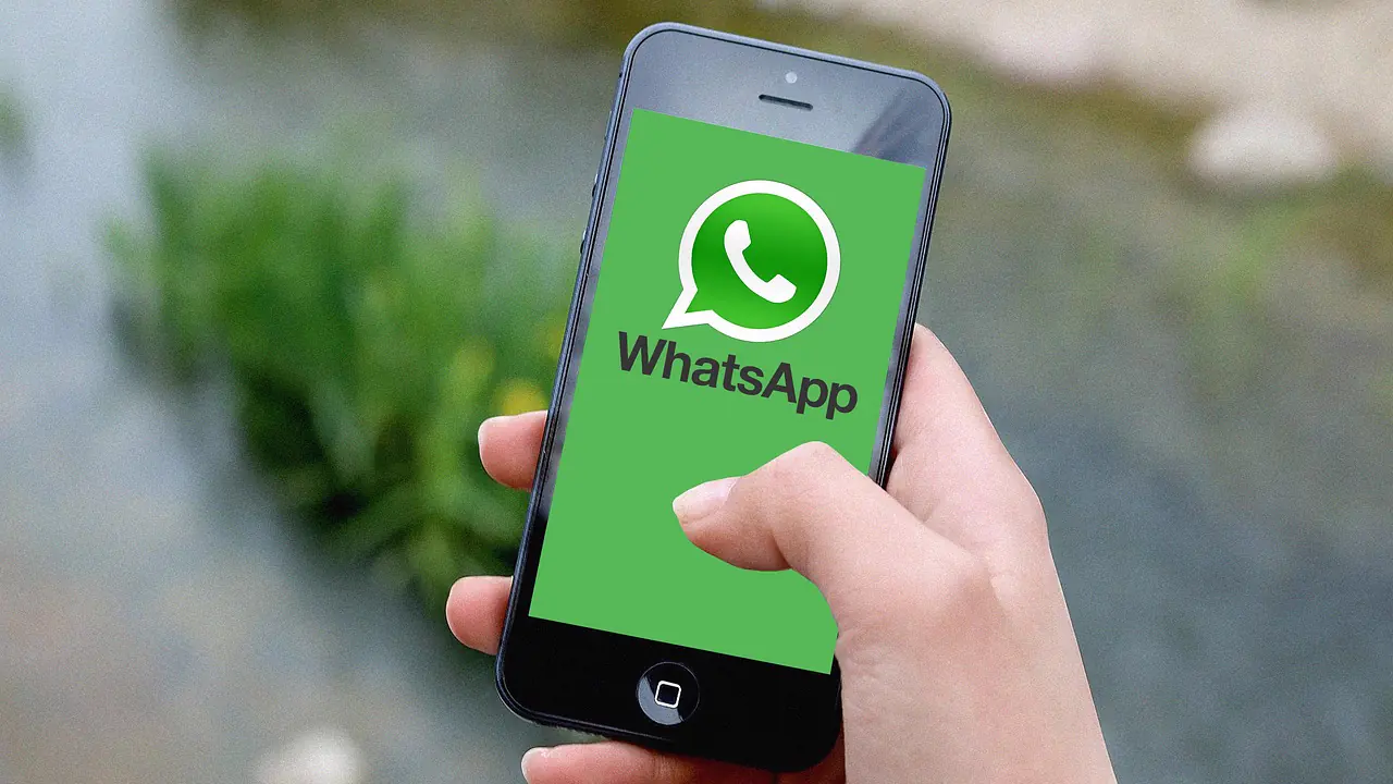 Persona sujetando un móvil para atender conversaciones de WhatsApp de un negocio
