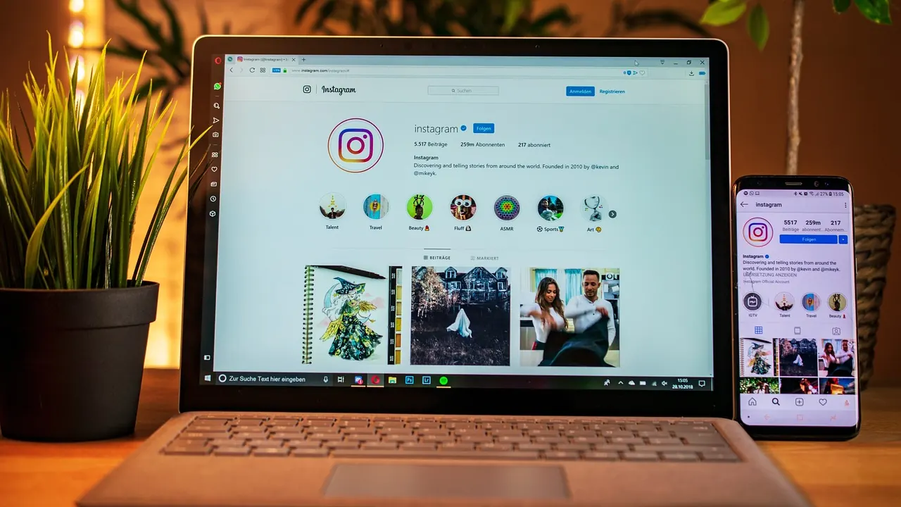 Portátil y móvil con Instagram en una mesa de trabajo para comparar una web propia con las redes sociales